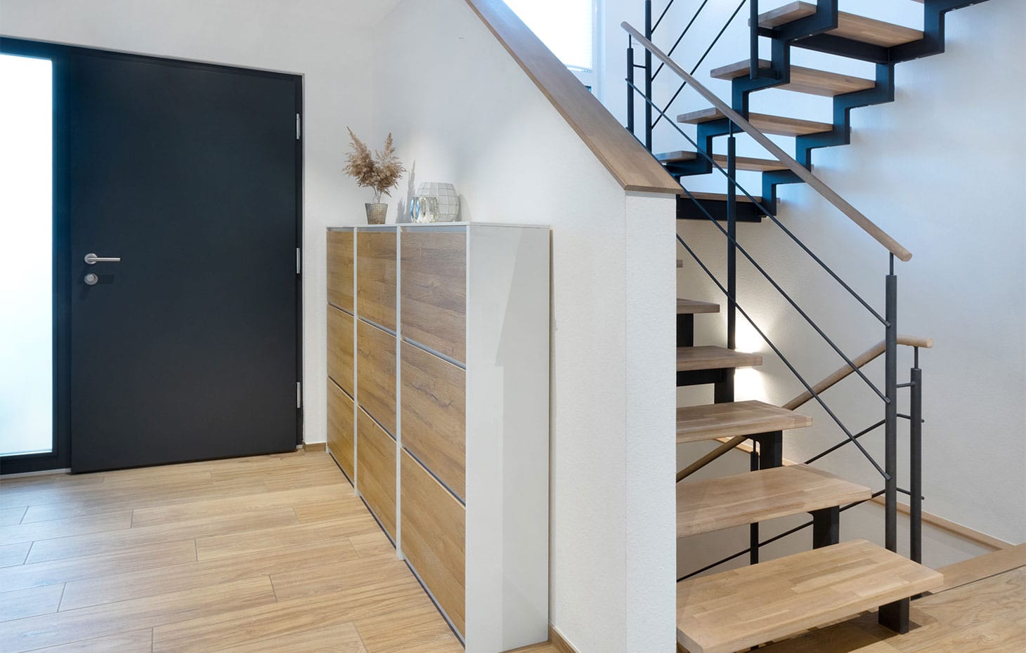 eingangsbereich-haustür-mit-satiniertem-glas-und-offener-treppe