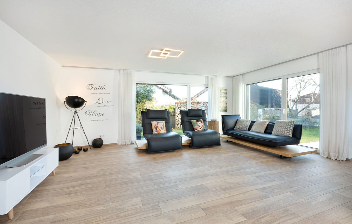 wohnzimmer-mit-großen-fenstern-sofa-und-tv