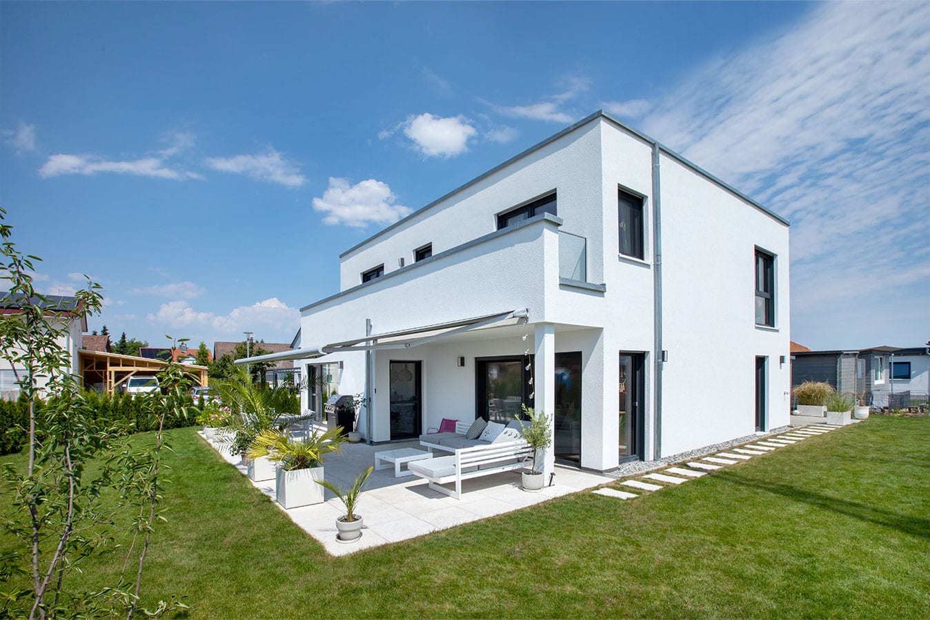 Modernes-effizienzhaus-mit-flachdach-außenansicht-garten-terrasse-fertighaus-balkon-verglasung