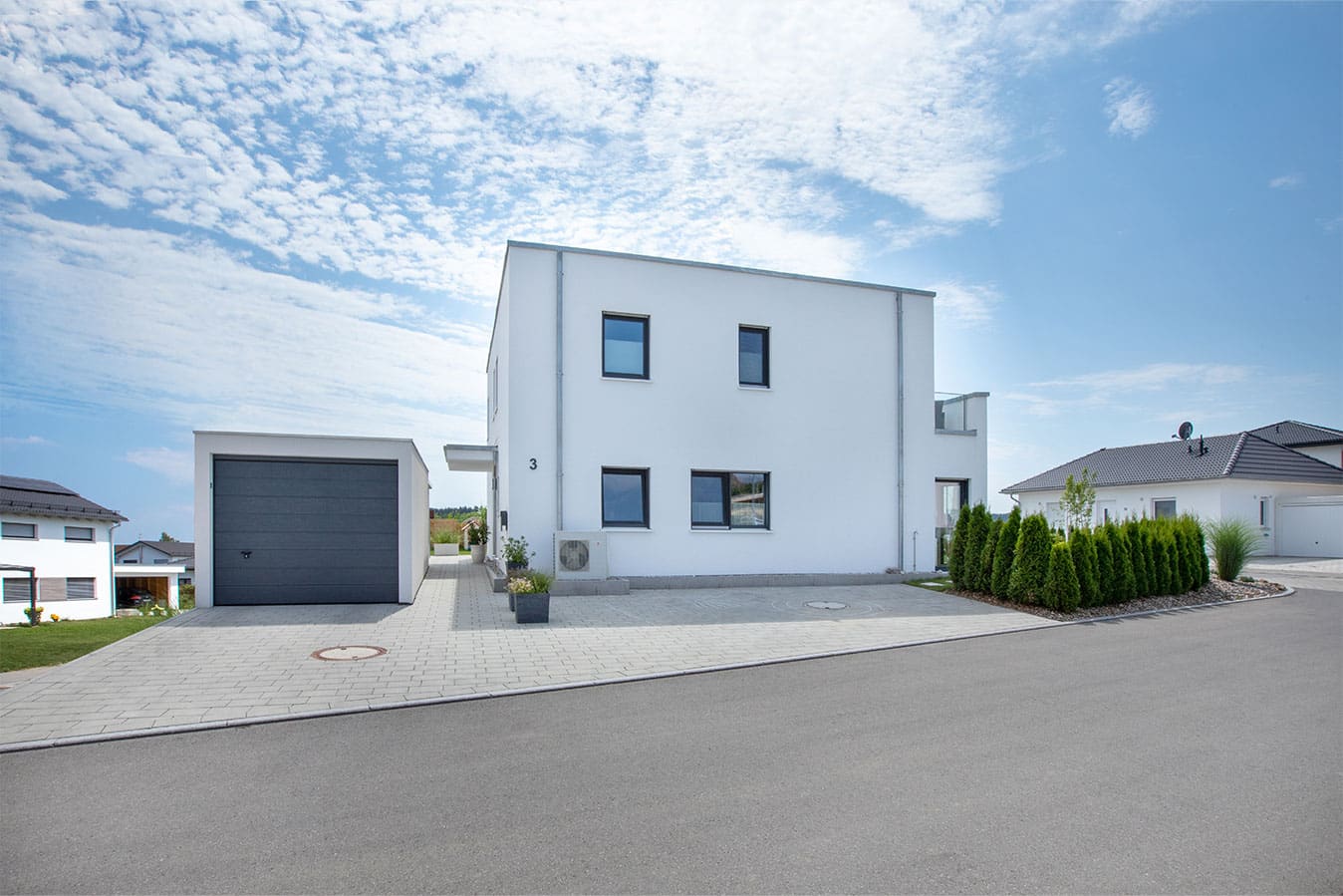 Modernes-effizienzhaus-mit-flachdach-außenansicht-stellplatz-garage-fertighaus