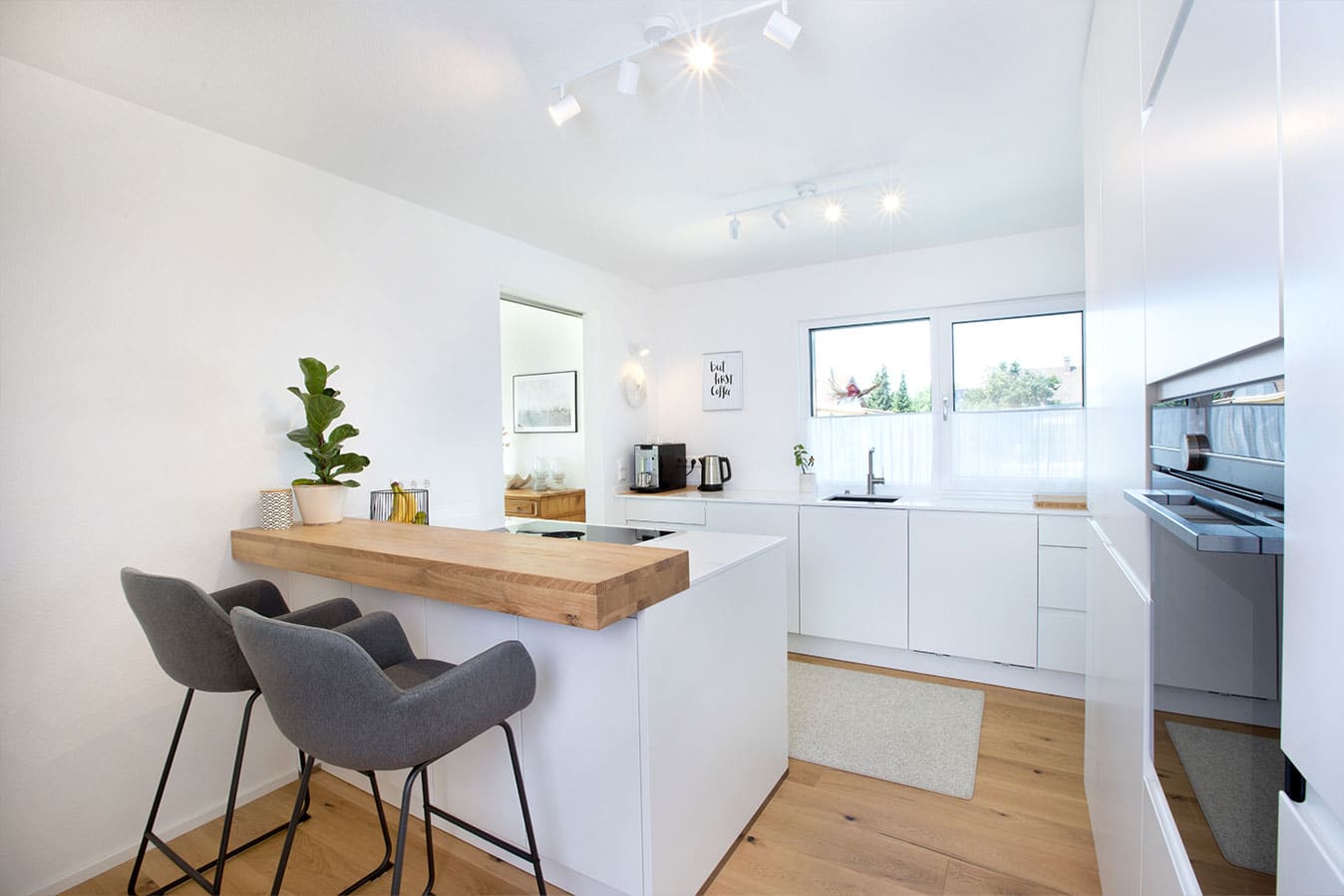 Modernes-effizienzhaus-mit-flachdach-kueche-essbereich-kochen-bar-fertighaus