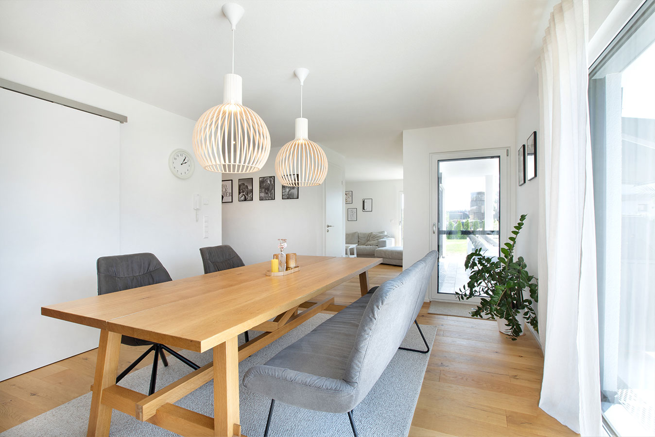Modernes-effizienzhaus-mit-flachdach-wohnzimmer-esstisch-essen-fertighaus-sofa
