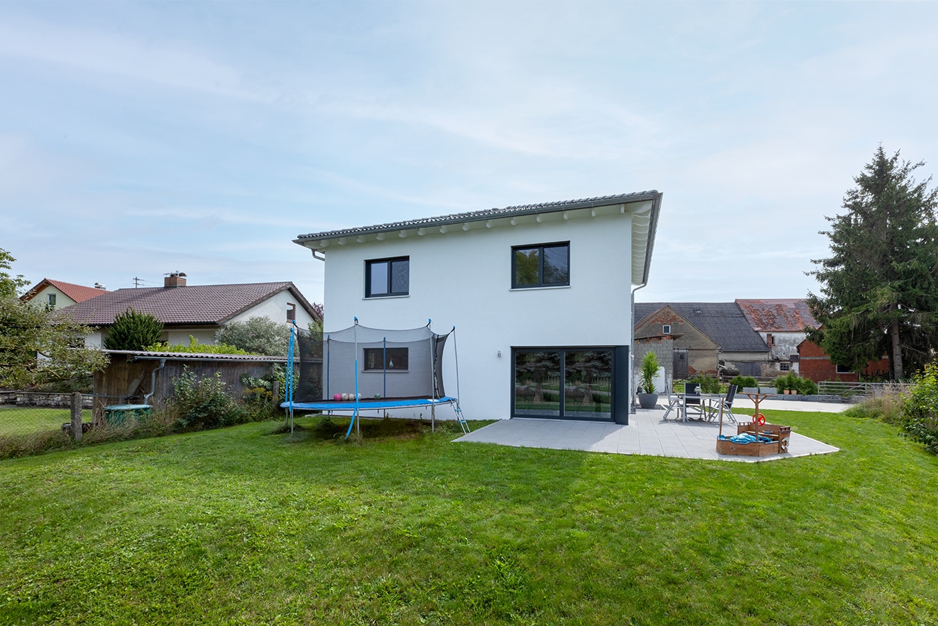 Moderne-Stadtvilla-mit-Walmdach-terrasse-garten-trampolin