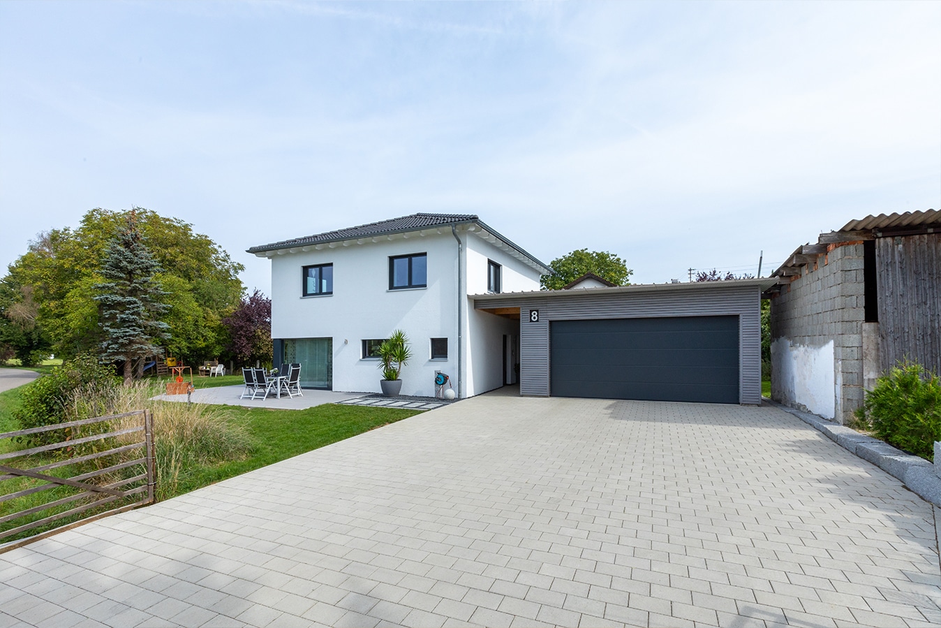 Moderne-Stadtvilla-mit-Walmdach-terrasse-stellplatz-einfahrt-haustuer-garage